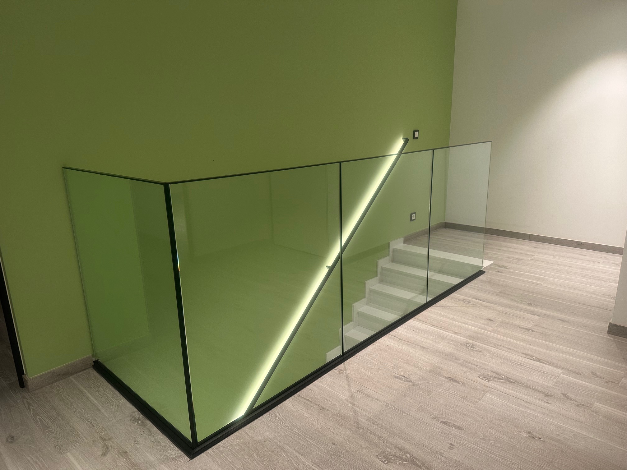Glazen balustrade op vide met bijhorende muurgreep en ingewerkte Ledverlichting - Balustrades project door Joos Technics