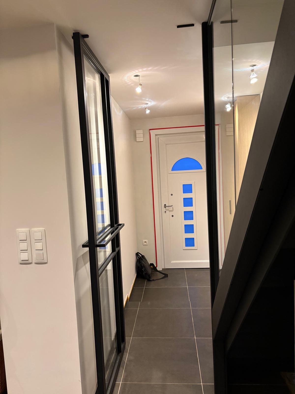 Stalen trap met glazen zijwand en pivoterende deur op maat - Balustrades project door Joos Technics